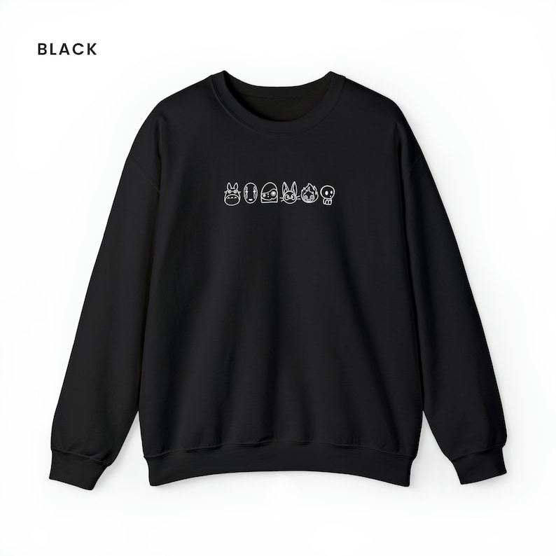 Puede incluir: Sudadera negra con un contorno blanco de personajes de dibujos animados en la parte delantera. Los personajes incluyen Totoro, Sin Cara, Jiji, Kiki y una calavera.