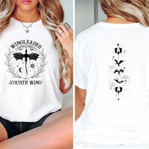 May include: White t-shirt with a black graphic design featuring a dragon and the text "WINGLEADER FOURTH WING". The back of the shirt has a vertical design of four dragons.