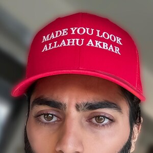 May include: Red baseball cap with white embroidered text that reads "MADE YOU LOOK ALLAHU AKBAR".
