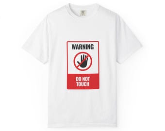 Puede incluir: Camiseta blanca con un diseño rojo y negro. El diseño muestra una mano dentro de un círculo rojo con una línea, y las palabras "WARNING" y "DO NOT TOUCH".