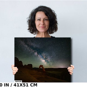 May include: A photograph of the Milky Way galaxy over Delicate Arch in Arches National Park, Utah. The arch is a natural sandstone arch, a popular tourist destination. The image is printed on canvas and measures 16x20 inches.