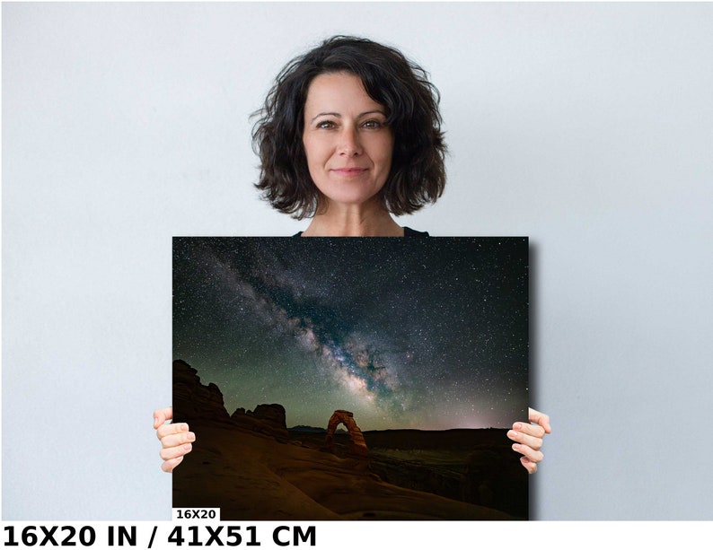 May include: A photograph of the Milky Way galaxy over Delicate Arch in Arches National Park, Utah. The arch is a natural sandstone arch, a popular tourist destination. The image is printed on canvas and measures 16x20 inches.