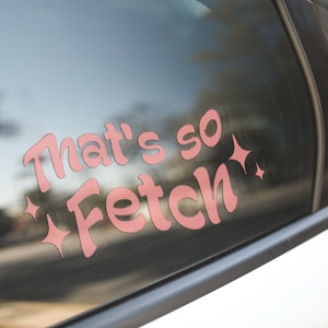 May include: A pink car window sticker with the text "That's so Fetch" and two sparkly stars on either side.
