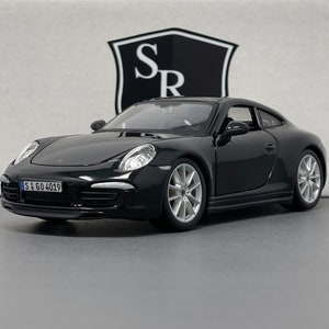 Puede incluir: Coche modelo Porsche 911 negro con una matrícula alemana que dice "S GO 4019".