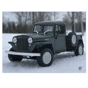May include: A green Jeep Willys pickup truck with a spare tire mounted on the back, parked in a snowy landscape.