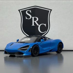 May include: A blue sports car model with black wheels and a black roof. The car is set against a white background with a black and white shield logo that reads "SRC".