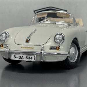 May include: Cream-coloured vintage convertible car model with chrome accents, a tan interior, and black tyres. The car has a number plate that reads "S-DA 534" and the word "Porsche" is visible on the front.