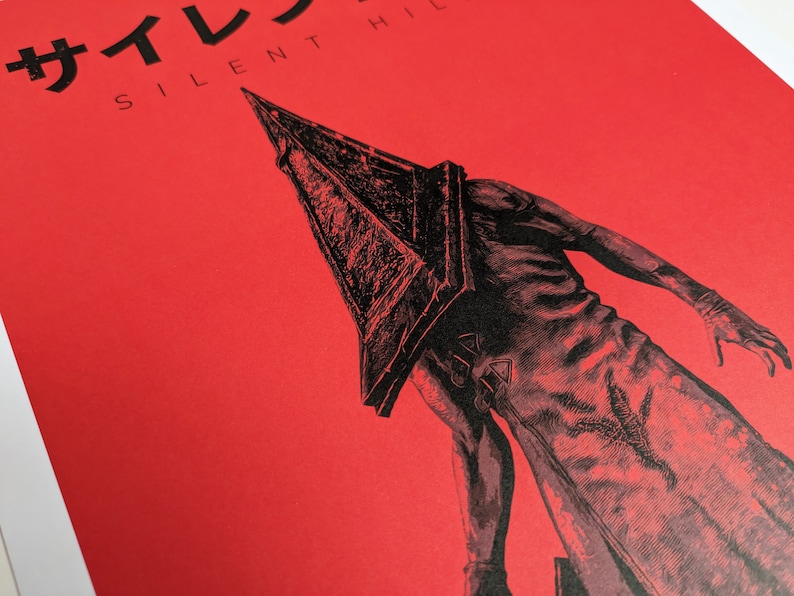 Silent Hill 2 Game Poster - Character set on a red background with a mixture of Japanese and English text in black. Available in A5, A4, A3 & A2. This close up photo shows the detail of the the main character.