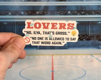 Op de afbeelding: Een sticker met het woord "LOVERS" in rode blokletters. De sticker heeft de tekst "NO, ILYA, THAT'S GROSS." en "NO ONE IS ALLOWED TO SAY THAT WORD AGAIN." De sticker wordt in een hand gehouden tegen een achtergrond van een ijshockeybaan.