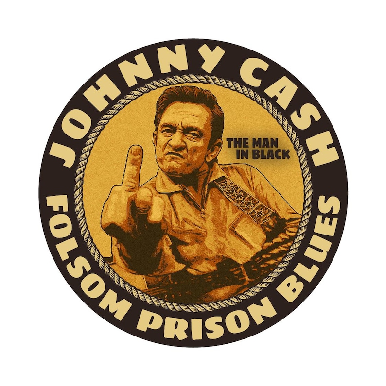 May include: Circular sticker featuring Johnny Cash, with the text "JOHNNY CASH" and "FOLSOM PRISON BLUES" in a brown font. Cash is depicted in a tan shirt, giving the middle finger. The text "THE MAN IN BLACK" is also present.