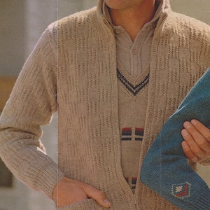 May include: A man wearing a beige knit cardigan with a matching sweater vest underneath. The vest has a V-neck and a navy and white pattern. The cardigan has a textured pattern and pockets. The text "25 SHETLAND FOR" is visible.