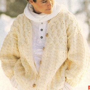 May include: Cream-colored, chunky knit cardigan with a diamond pattern. The sweater has large wooden buttons and is worn over a white shirt and scarf. The overall style suggests a cozy, winter-themed garment.