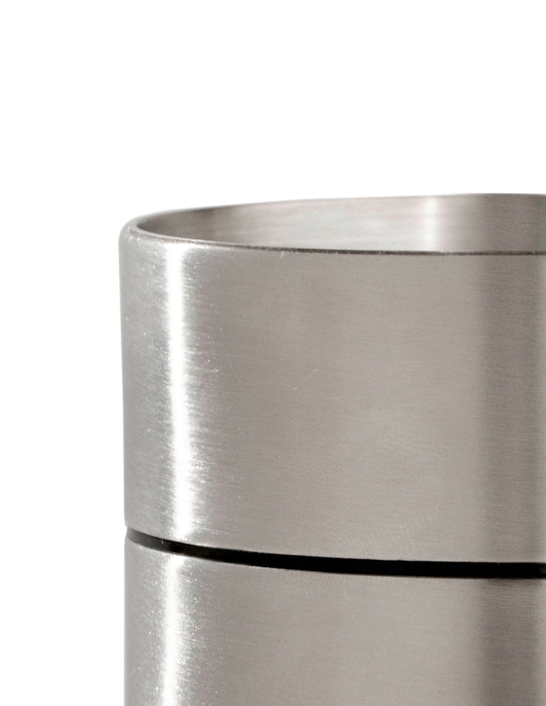 May include: A silver metal container with a brushed finish. The container has a lid and is made of two separate pieces.