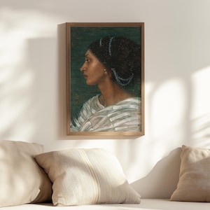 Op de afbeelding: Een ingelijst schilderij van een vrouw met donker haar en een witte jurk. De vrouw kijkt naar de zijkant en heeft een blauw en groen hoofddeksel. De achtergrond is donkergroen.