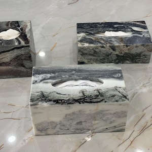 May include: Three marble tissue box covers in different shades of grey and green. The covers are square and rectangular in shape.