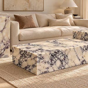 May include: A set of three furniture pieces made of white marble with prominent dark purple veining. The set includes a tall rectangular pedestal, a low rectangular coffee table, and a smaller square side table, all featuring a polished finish.