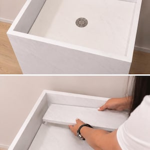 Puede incluir: Un lavabo cuadrado con patr&oacute;n de m&aacute;rmol blanco y un desag&uuml;e met&aacute;lico circular central. El dise&ntilde;o cuenta con un panel plano extra&iacute;ble que se asienta al ras dentro del recipiente, permitiendo una apariencia uniforme y una funcionalidad de drenaje.