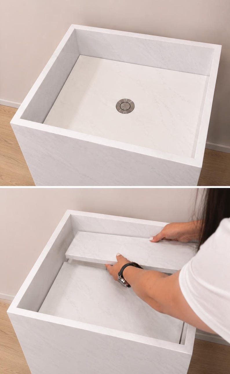 Puede incluir: Un lavabo cuadrado con patr&oacute;n de m&aacute;rmol blanco y un desag&uuml;e met&aacute;lico circular central. El dise&ntilde;o cuenta con un panel plano extra&iacute;ble que se asienta al ras dentro del recipiente, permitiendo una apariencia uniforme y una funcionalidad de drenaje.