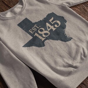 A grey sweatshirt with a texas silhouette that says "est. 1845"