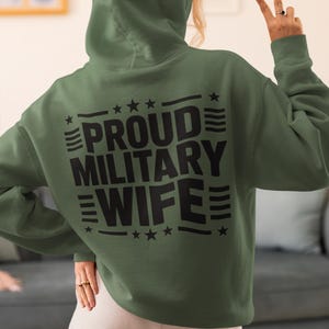 A woman in a army green sweatshirt that says proud military wife