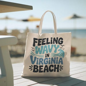 a white canvas beach bag that says "Feeling wavy in virginia beach"