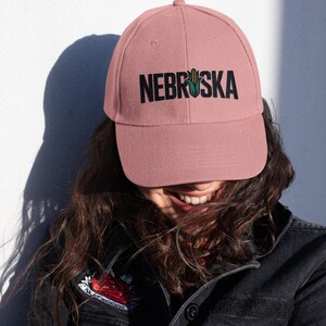 A girl wearing a pink hat that has a corn graphic