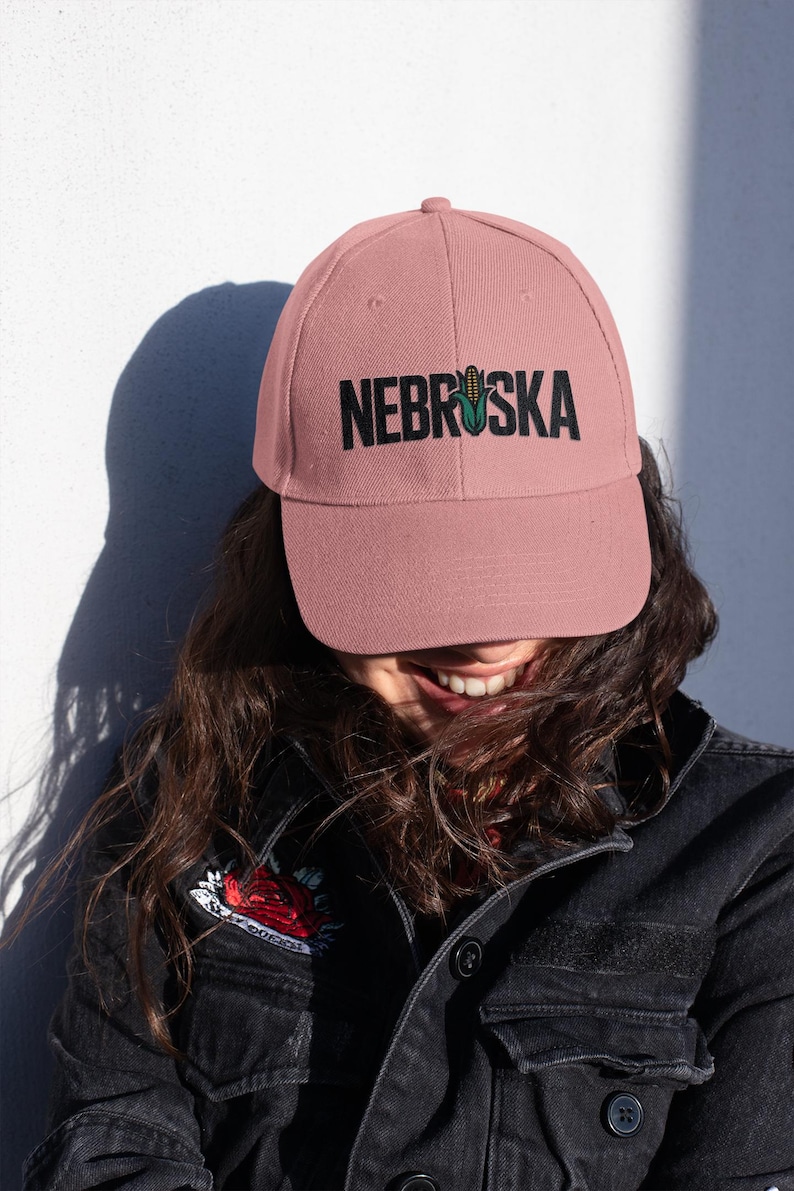 A girl wearing a pink hat that has a corn graphic