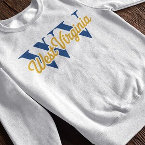 a heather white sweatshirt that says "WV West Virginia". this design is part of  A collection of west virginia vector designs perfect for cricut, silhouette, sublimation, DTF Printing, POD, tshirts, mugs, tote bags and more!