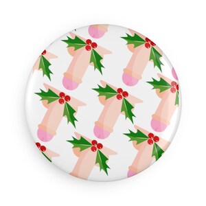 May include: A white button with a repeating pattern of pink and white figures with green holly and red berries.