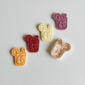 Pu&ograve; includere: Quattro stampini per biscotti a forma di bicchiere di t&egrave; freddo con una fetta di limone e una cannuccia. Gli stampini sono di vari colori: rosso, giallo e bianco. Uno stampino &egrave; bianco e sembra essere lo stampino originale.