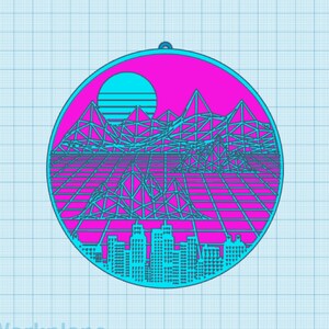 Könnte beinhalten: Ein runder, blauer und rosa Anhänger mit einer Skyline, Bergen und einer Sonne im Retro-Stil der 80er Jahre.