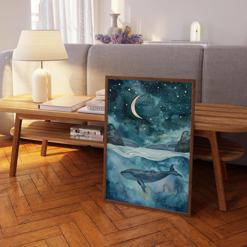 a painting of a whale swimming in the ocean, with a crescent moon and stars in the night sky above it. The painting is displayed on a wooden table in a living room setting.