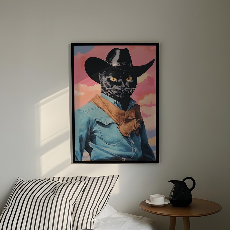 a framed picture of a black cat wearing a cowboy hat and a blue denim shirt, hanging on a wall above a bed with a striped pillow.
