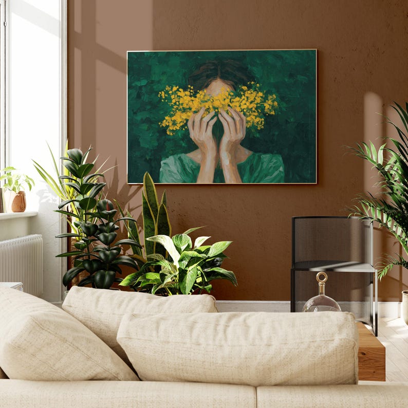 a cozy living room with a large painting of a woman's face partially obscured by yellow flowers hanging on the wall above a beige sofa.