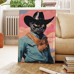 A framed painting of a black cat wearing a cowboy hat and blue denim jacket, with a colorful background.