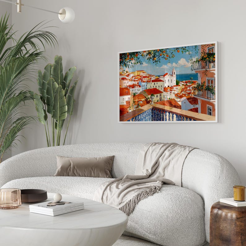a cozy living room with a white sofa, a round coffee table, and a framed painting of a colorful cityscape hanging on the wall.