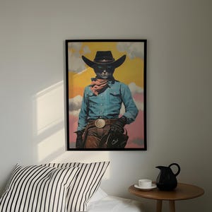 a framed poster of a cat dressed as a cowboy, wearing a blue shirt, brown pants, and a cowboy hat, standing against a colorful background.