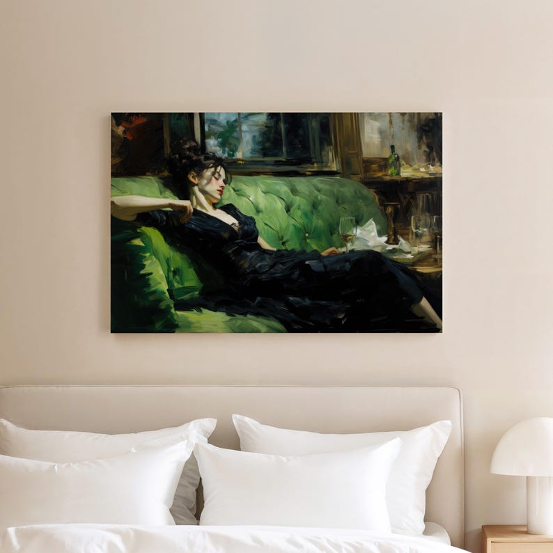 a woman in a black dress sitting on a green couch, with a wine glass and a bottle of wine nearby.