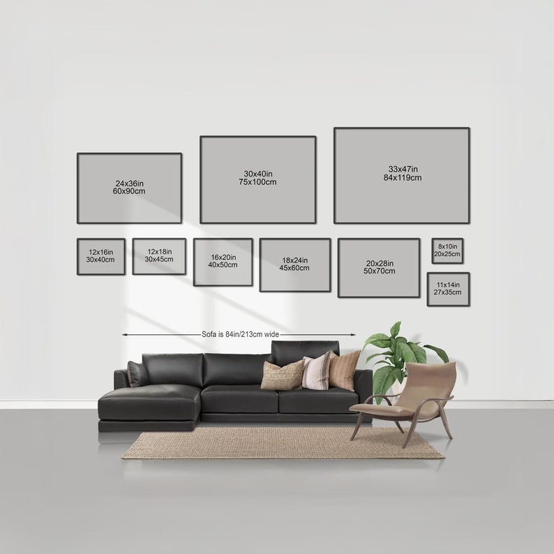 a living room with a black leather sofa and a chair, along with a rug on the floor. Above the furniture, there are nine framed artworks of varying sizes, each with a different width and height, ranging from 24x36 to 60x90cm. The artworks are arranged in a grid-like pattern on the wall, creating a visually appealing display.