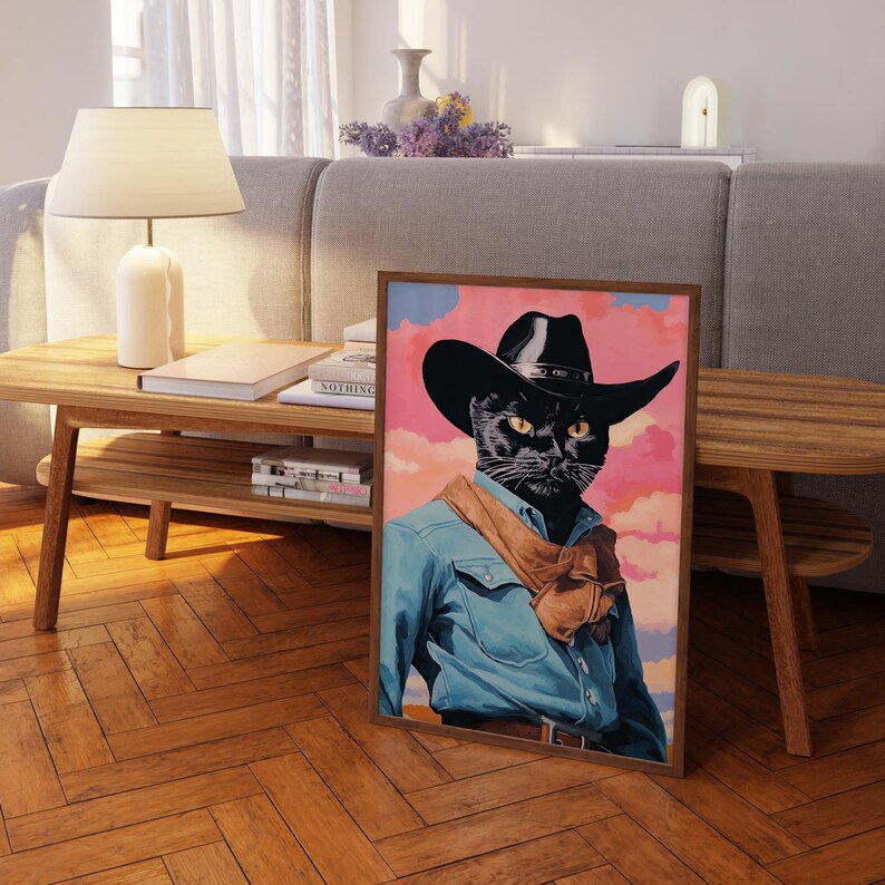 a framed painting of a cat wearing a cowboy hat and blue denim jacket, sitting on a wooden floor in a living room setting.