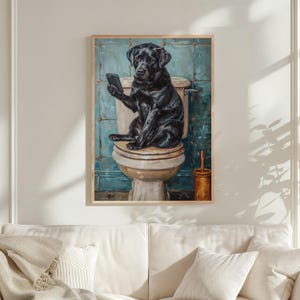 A black dog sitting on a toilet and holding a cell phone in its paws, as if using it.