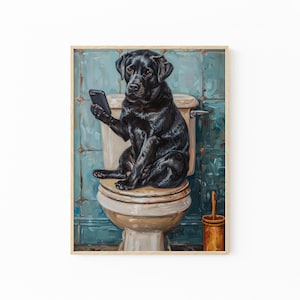 A black dog sitting on a toilet and holding a cell phone.