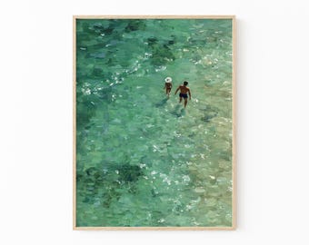 May include: A framed art print showing two people in turquoise water. One person wears a hat. The water's surface is textured with brushstrokes, creating a sense of movement and depth. The artwork evokes a tranquil beach scene.