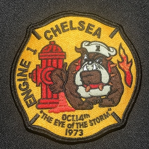 May include: Yellow and black embroidered patch with a bulldog wearing a sailor hat, a fire hydrant, and the text "Chelsea Engine 1 Oct 14th The Eye of the Storm 1973".