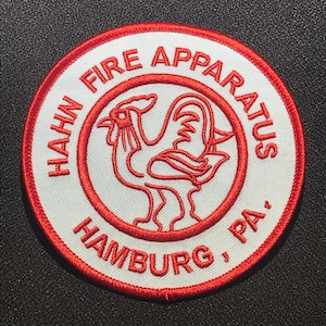 Könnte beinhalten: Roter und weißer gestickter Aufnäher mit dem Text "Hahn Fire Apparatus Hamburg, PA."