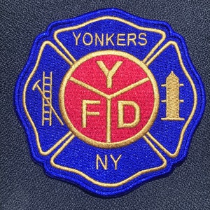 Könnte beinhalten: Ein blauer und goldener gestickter Aufnäher mit den Worten "Yonkers FD NY" und einem roten Kreis mit einem goldenen "Y" darin.