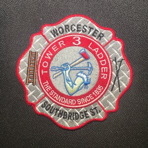 May include: A red, white, and gray embroidered patch with the words "Worcester Tower 3 Ladder The Standard Since 1885 Southbridge St."