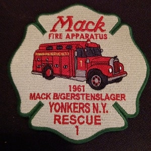 May include: A green and white embroidered patch with a red fire truck, the text "Mack Fire Apparatus", "1961 Mack B/gers tenslager Yonkers N.Y. Rescue 1", and the number "1" in the center.