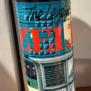 May include: A stainless steel tumbler featuring a colorful design inspired by the video game "The Legend of Zelda." The design includes the game's logo, pixelated graphics, and iconic imagery. The tumbler has a clear lid.