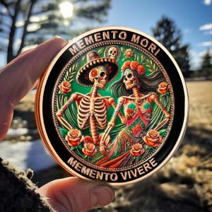 May include: A copper-colored round coin with a black border and a colorful image of two skeletons in a romantic embrace. The skeletons are adorned with floral patterns and the coin reads "Memento Mori" and "Memento Vivere" in a circular design.